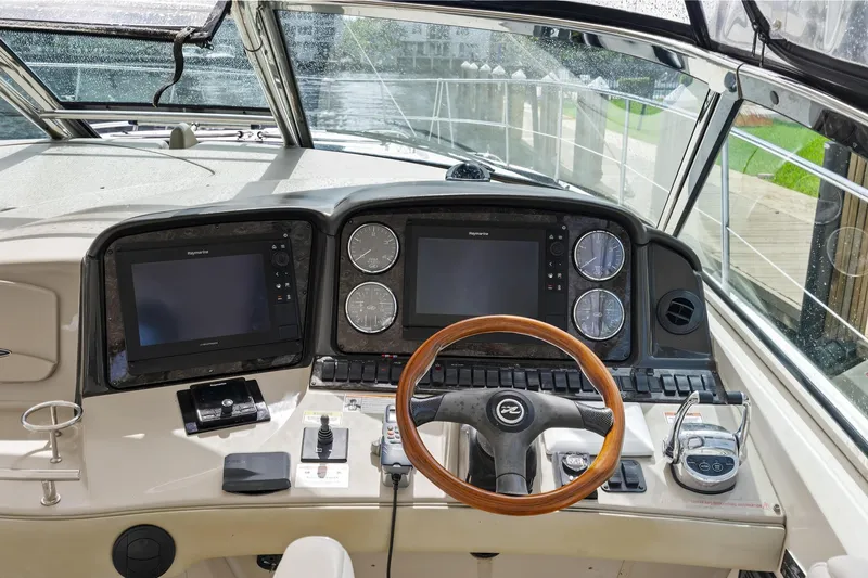 Slide: The Image of 2008 Sea Ray 44 Sundancer helm with dual displays and wooden steering wheel. - 15