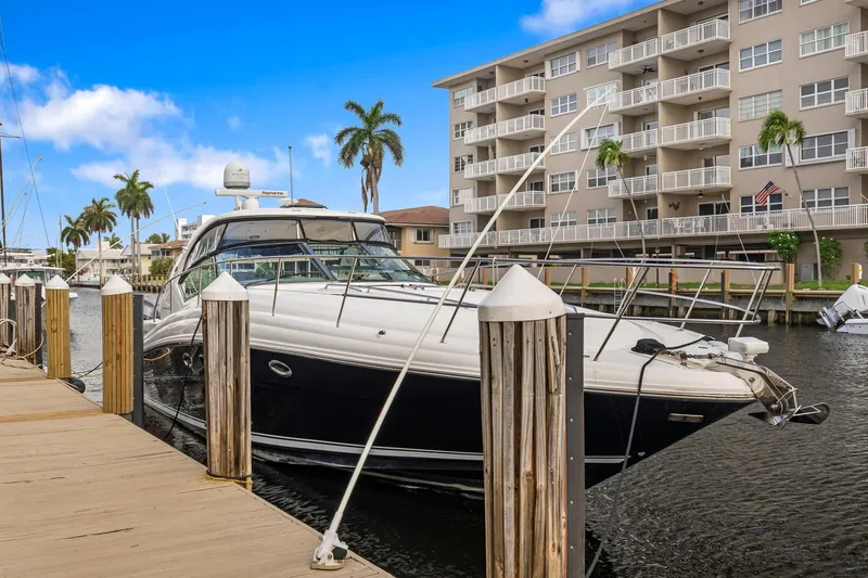 Slide: The Image of 2008 Sea Ray 44 Sundancer yacht docked near waterfront apartments. - 2