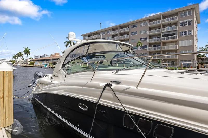 Slide: The Image of 2008 Sea Ray 44 Sundancer yacht docked near waterfront apartments. - 7