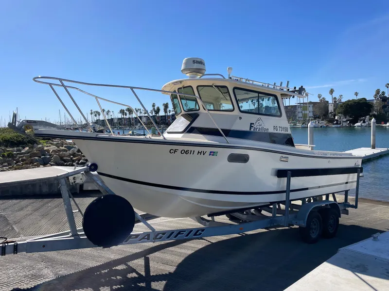 Slide: The Image of 1984 Farallon 25 Whaleback boat on a trailer at a marina. - 1