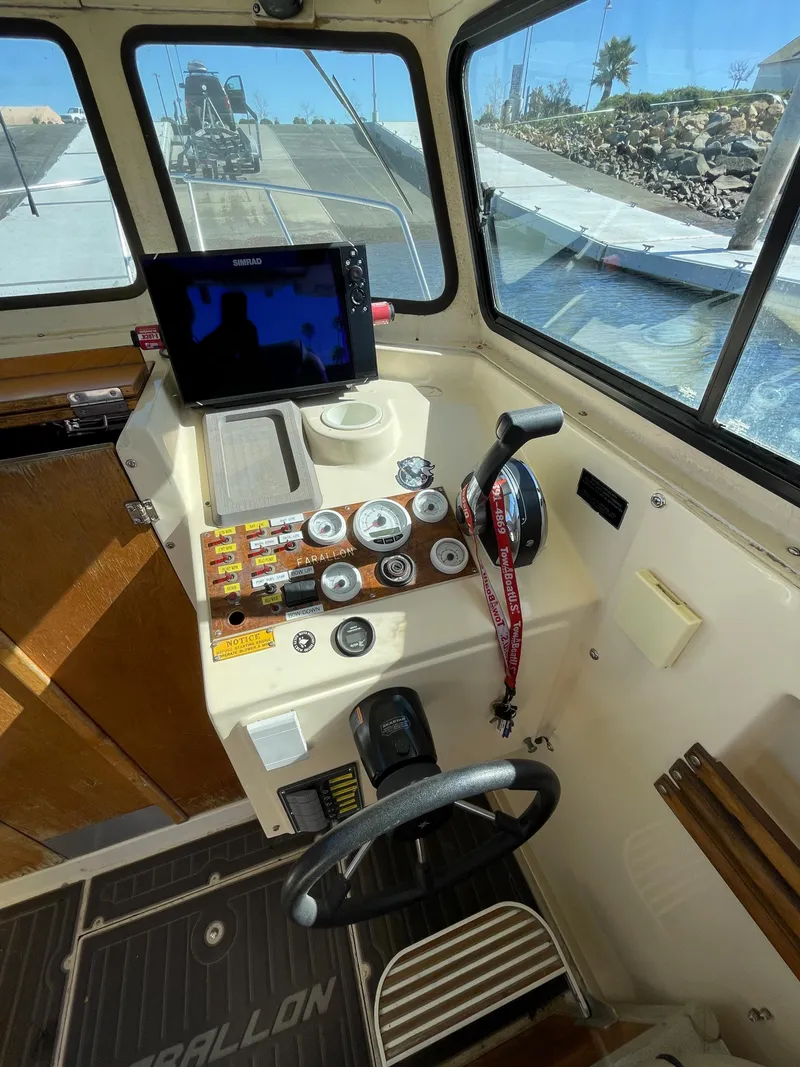 Slide: The Image of 1984 Farallon 25 Whaleback boat cockpit with navigation equipment and steering wheel. - 12