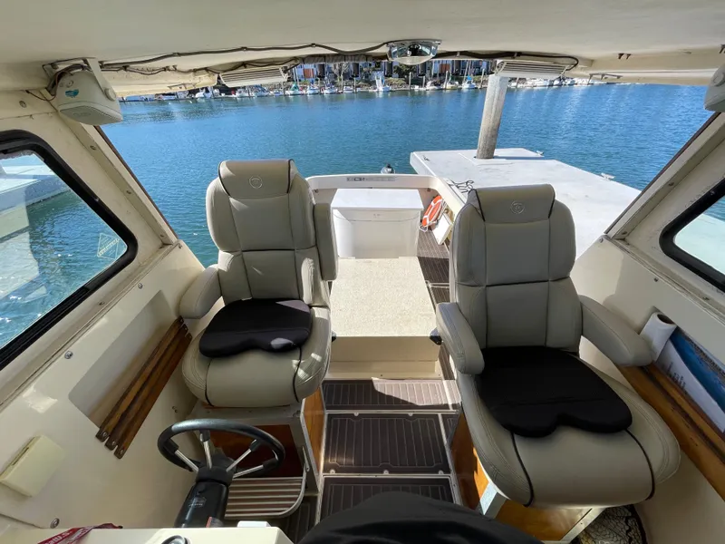 Slide: The Image of Interior of 1984 Farallon 25 Whaleback boat with two cushioned seats, docked at marina. - 13