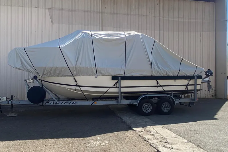 Slide: The Image of 1984 Farallon 25 Whaleback boat covered on a trailer in a storage area. - 17
