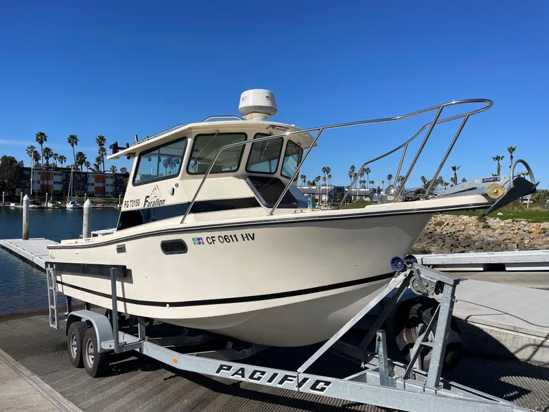 Slide: The Image of 1984 Farallon 25 Whaleback boat on a trailer at a marina. - 2