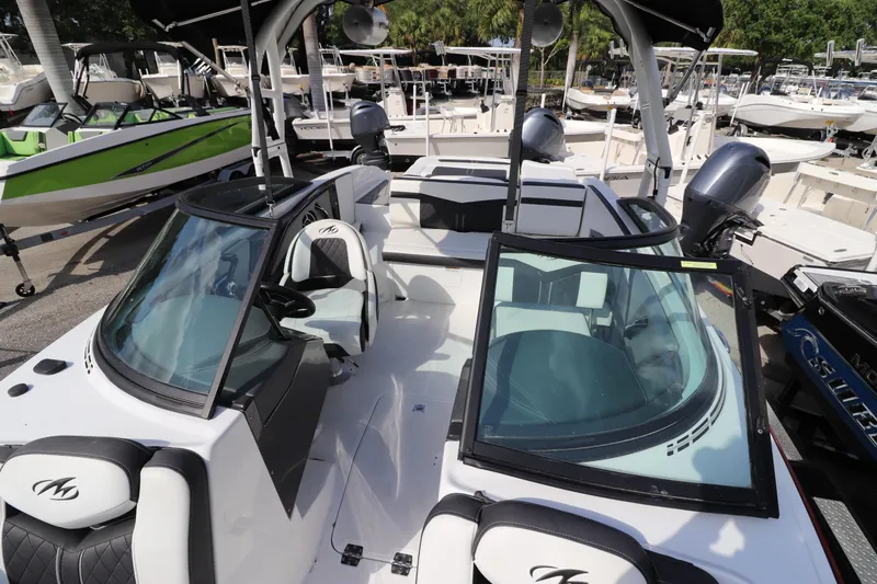 Slide: The Image of 2018 Monterey 238SS boat with dual windshields and seating, docked at a marina. - 5