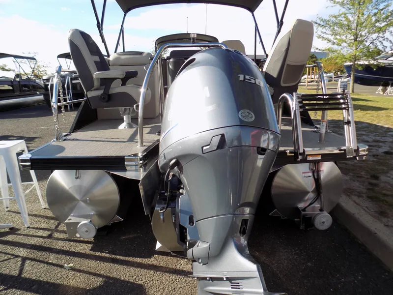 Slide: The Image of 2023 Barletta C22CC pontoon boat with powerful outboard motor, docked outdoors. - 12