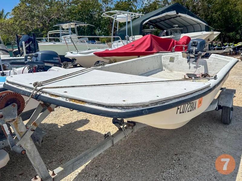 Slide: The Image of 1998 Carolina Skiff J12 Skiff boat on trailer in a marina. - 11