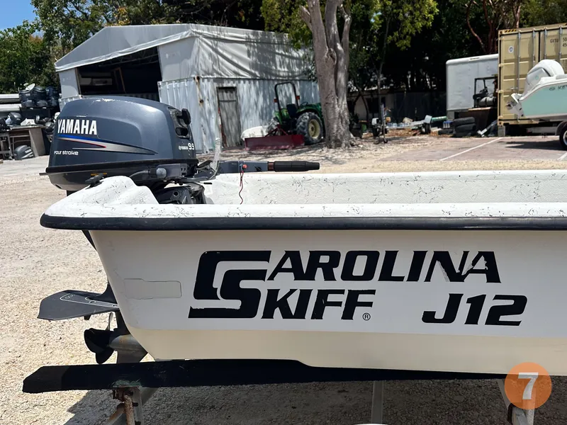 Slide: The Image of 1998 Carolina Skiff J12 boat with Yamaha outboard motor in a yard. - 6