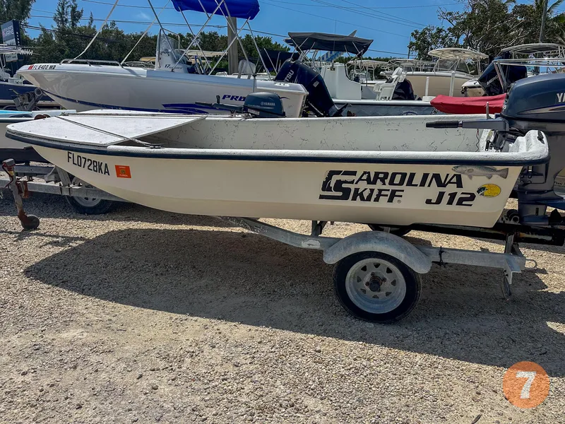Slide: The Image of 1998 Carolina Skiff J12 Skiff boat on a trailer in a marina. - 7