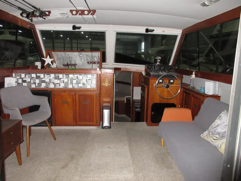 Slide: The Image of Interior of a 1978 Pacemaker 40 Sport Fish boat with helm, seating, and wooden cabinetry. - 12
