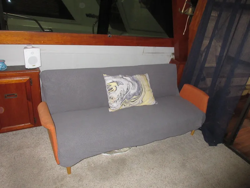 Slide: The Image of Interior of 1978 Pacemaker 40 Sport Fish with a gray sofa and decorative pillow. - 13