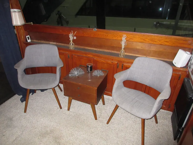 Slide: The Image of Two gray chairs and a wooden table inside a 1978 Pacemaker 40 Sport Fish boat. - 17