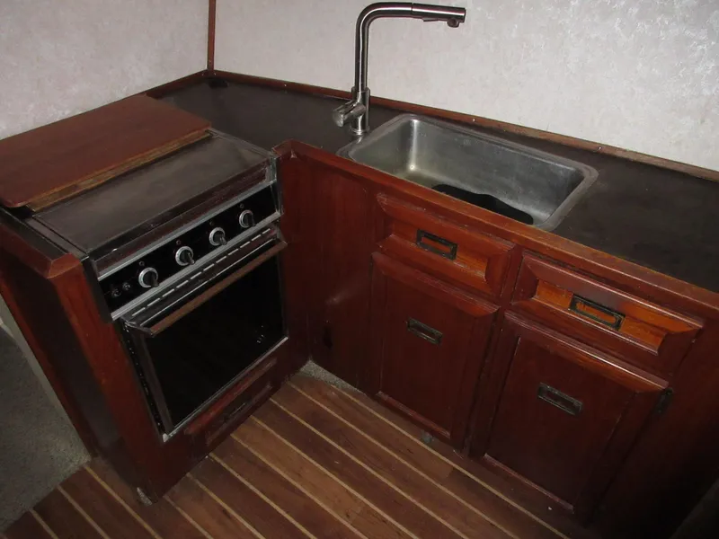 Slide: The Image of 1978 Pacemaker 40 Sport Fish boat kitchen with stove, sink, and wooden cabinets. - 22