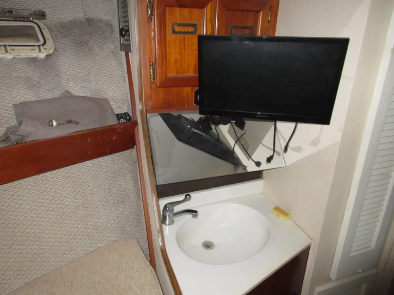 Slide: The Image of 1978 Pacemaker 40 Sport Fish interior with sink, TV, and wooden cabinets. - 24