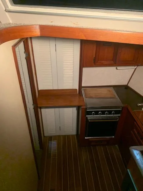 Slide: The Image of 1978 Pacemaker 40 Sport Fish boat kitchen with stove and wooden cabinets. - 38