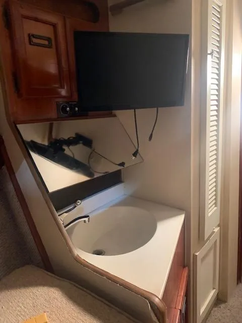 Slide: The Image of 1978 Pacemaker 40 Sport Fish interior with sink, mirror, and mounted TV. - 40