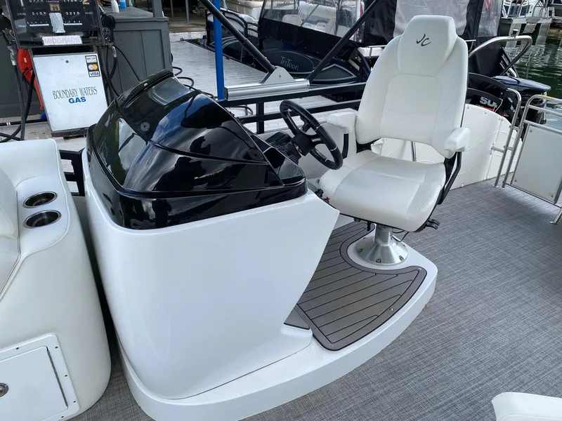 Slide: The Image of 2023 JC Neptoon Sport 23TT boat helm with white captain's chair and black dashboard. - 14