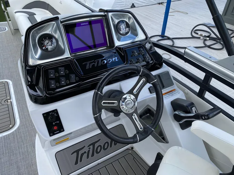 Slide: The Image of 2023 JC Neptoon Sport 23TT boat dashboard with steering wheel and control panel. - 17