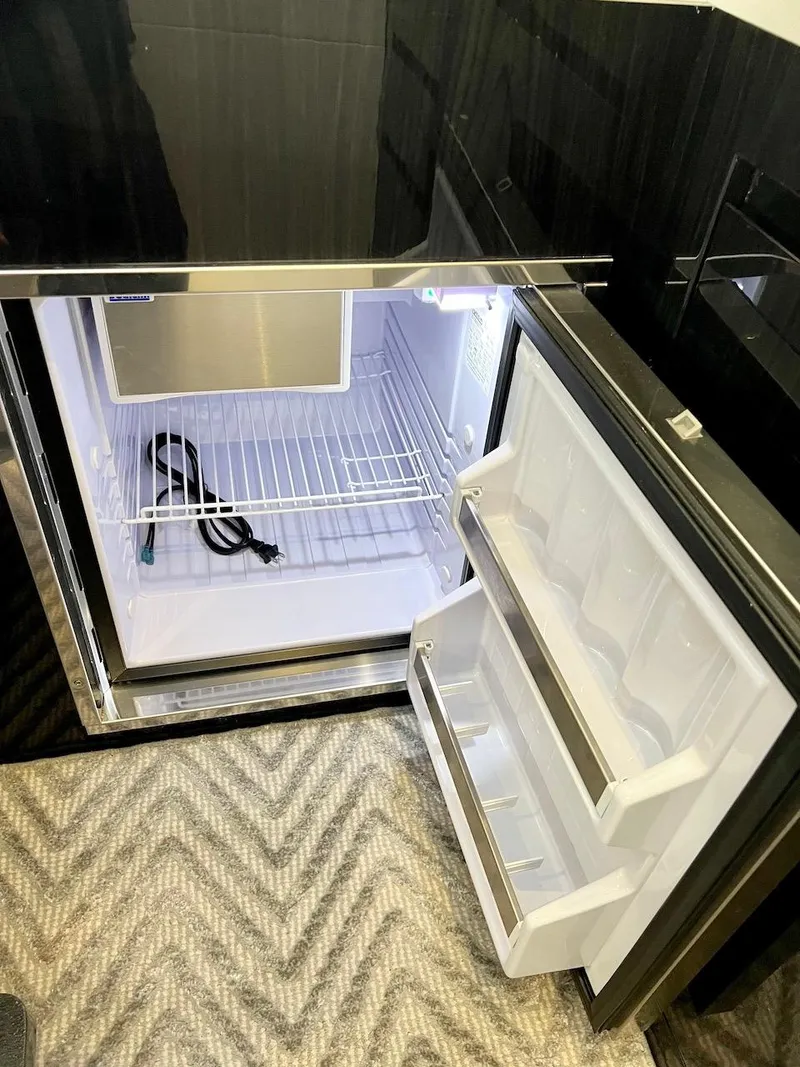 Slide: The Image of Open refrigerator inside Schaefer 400 Sport yacht, 2025 model, with empty shelves and door compartments. - 19