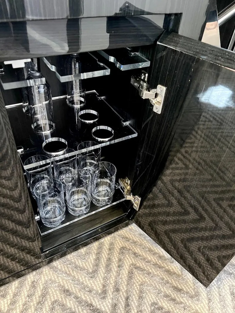 Slide: The Image of Glassware storage in a 2025 Schaefer 400 Sport yacht, featuring sleek black cabinetry. - 20