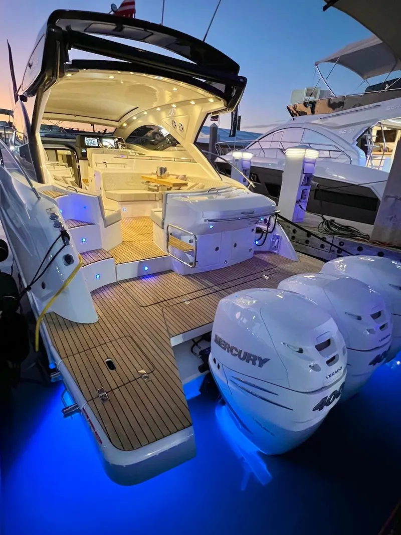 Slide: The Image of Schaefer 400 Sport 2025 yacht with illuminated deck and twin Mercury engines at sunset. - 38