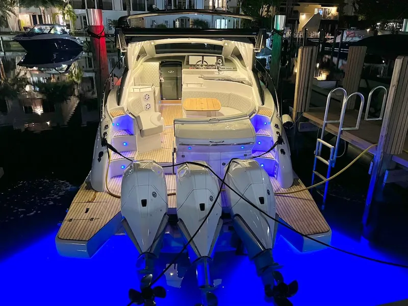 Slide: The Image of 2025 Schaefer 400 Sport yacht with illuminated deck and triple outboard motors at night. - 40