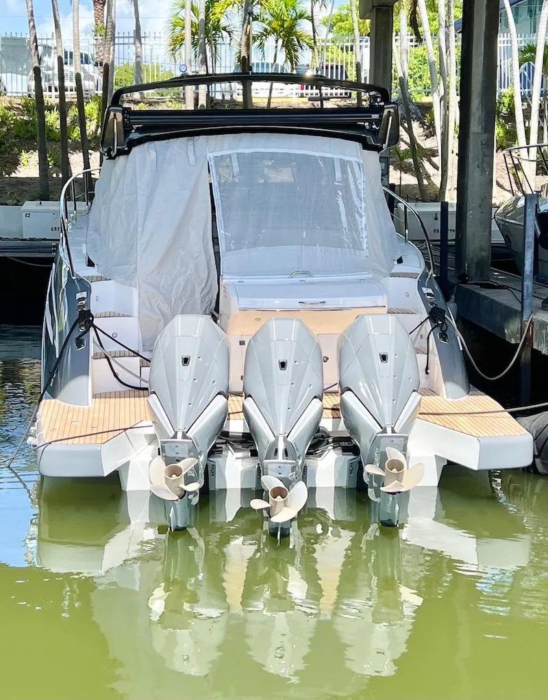 Slide: The Image of 2025 Schaefer 400 Sport boat with triple outboard engines docked in marina. - 41