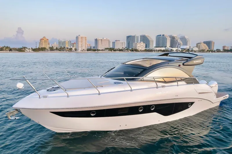 Slide: The Image of 2025 Schaefer 400 Sport yacht cruising near city skyline. - 6