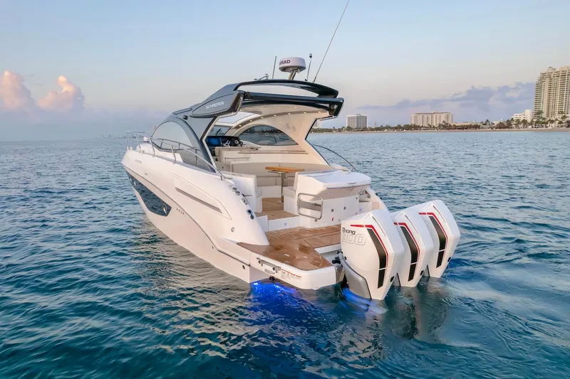 Slide: The Image of 2025 Schaefer 400 Sport yacht on calm ocean near city skyline. - 9