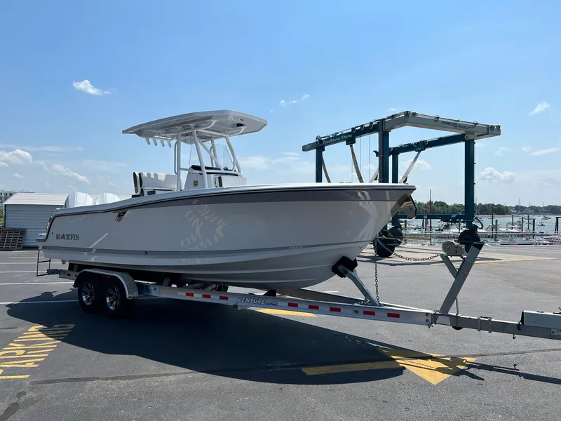 Slide: The Image of 2023 Blackfin 252 CC boat on a trailer at a marina. - 12