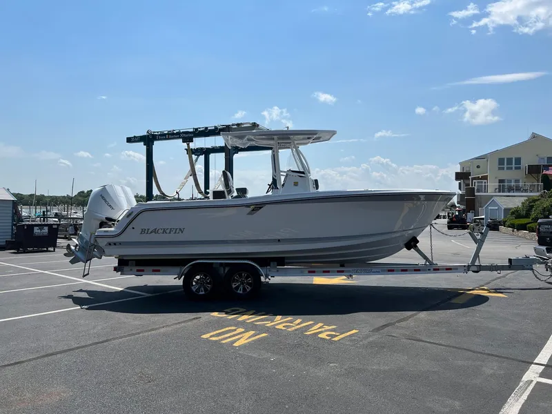 Slide: The Image of 2023 Blackfin 252 CC boat on a trailer in a parking lot. - 13