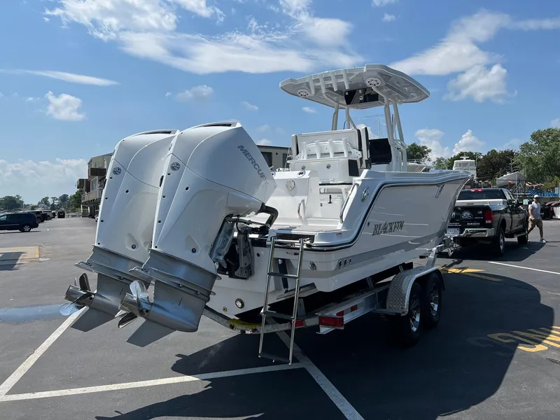 Slide: The Image of 2023 Blackfin 252 CC boat with twin outboard engines on a trailer. - 14