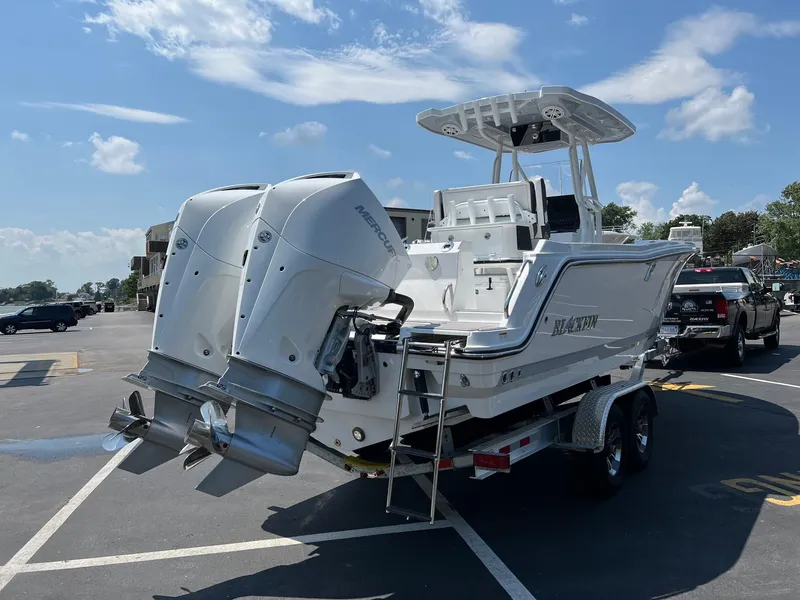 Slide: The Image of 2023 Blackfin 252 CC boat with twin outboard engines on a trailer. - 15