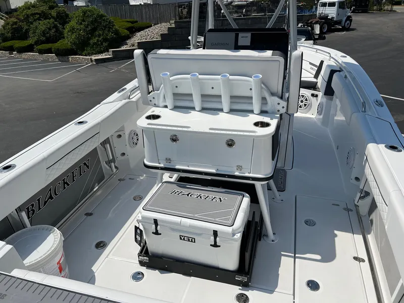 Slide: The Image of 2023 Blackfin 252 CC boat interior with fishing rod holders and Yeti cooler. - 23