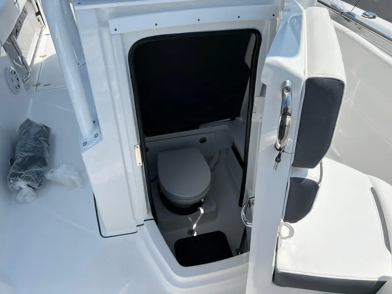 Slide: The Image of 2023 Blackfin 252 CC boat interior with a compact marine toilet. - 29