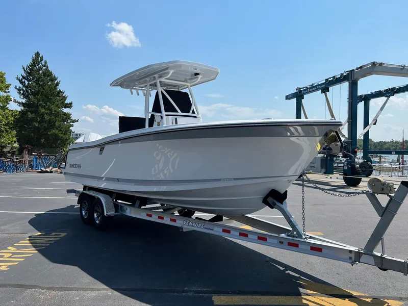 Slide: The Image of 2023 Blackfin 252 CC boat on a trailer in a marina parking lot. - 35