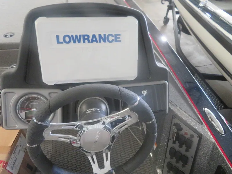 Slide: The Image of 2022 Caymas CX19 boat dashboard with Lowrance display and steering wheel. - 2