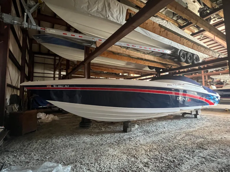 The Image of 2001 Donzi 38 ZX boat stored indoors, featuring sleek design and vibrant colors. - 0