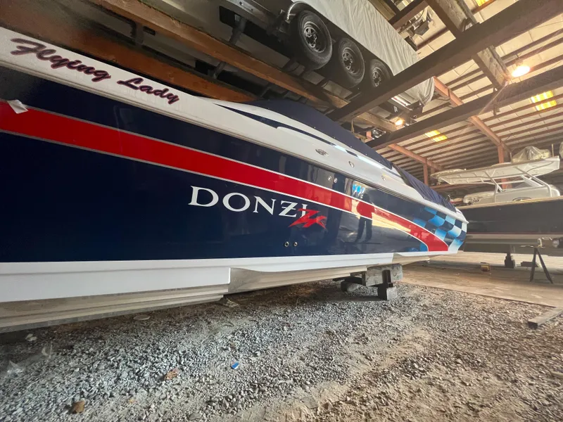 Slide: The Image of 2001 Donzi 38 ZX boat in storage, featuring a sleek design with red and blue accents. - 2