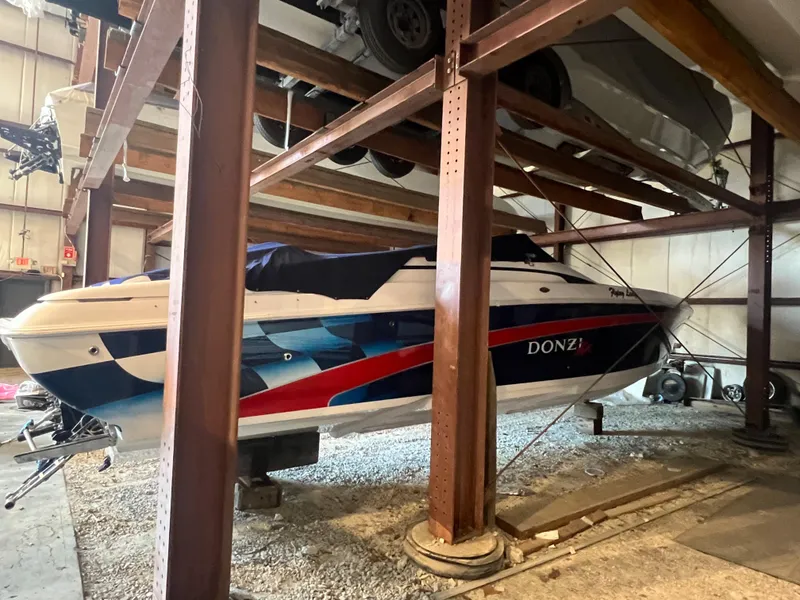 Slide: The Image of 2001 Donzi 38 ZX boat stored in a warehouse, featuring a vibrant blue and red design. - 5