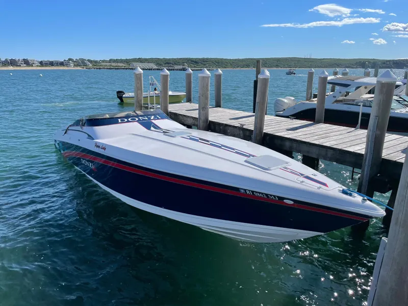 Slide: The Image of 2001 Donzi 38 ZX speedboat docked on clear blue water under a sunny sky. - 7