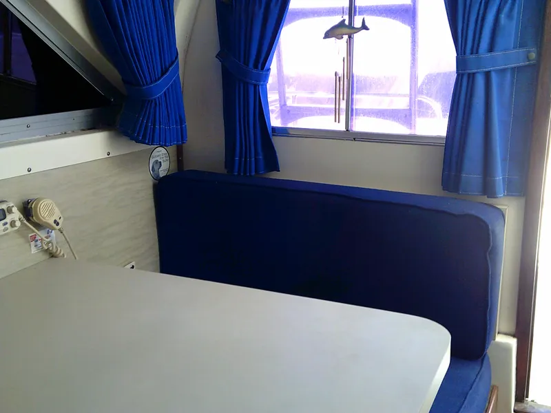 Slide: The Image of Interior of 1980 Bertram 28 Flybridge Cruiser with blue seating and curtains. - 17