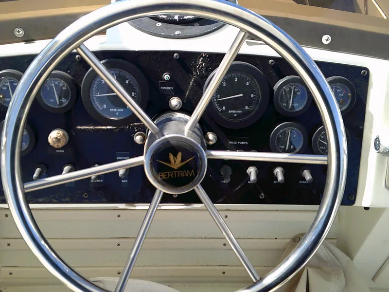 Slide: The Image of 1980 Bertram 28 Flybridge Cruiser dashboard with steering wheel and gauges. - 19
