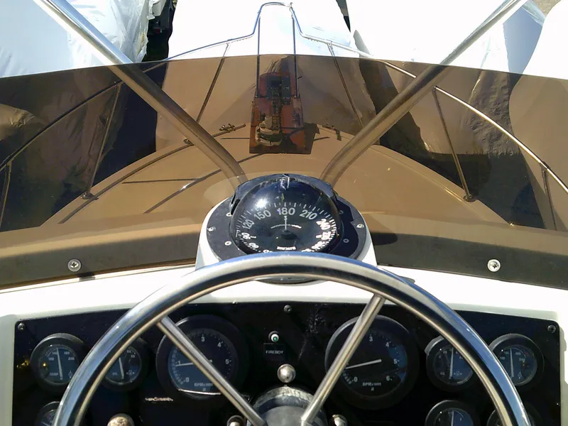 Slide: The Image of 1980 Bertram 28 Flybridge Cruiser helm with compass and instrument panel. - 22