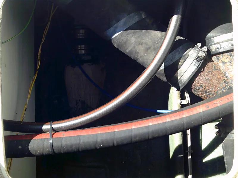 Slide: The Image of Engine compartment of a 1980 Bertram 28 Flybridge Cruiser with visible hoses and clamps. - 6