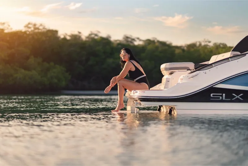 Slide: The Image of Woman relaxing on 2023 Sea Ray SLX 260 boat at sunset. - 11