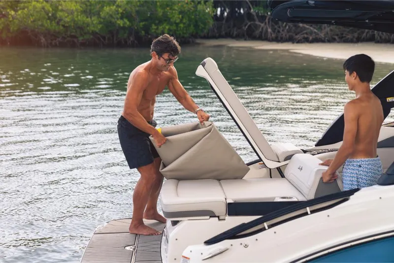 Slide: The Image of 2023 Sea Ray SLX 260 boat with people enjoying the deck by the water. - 12