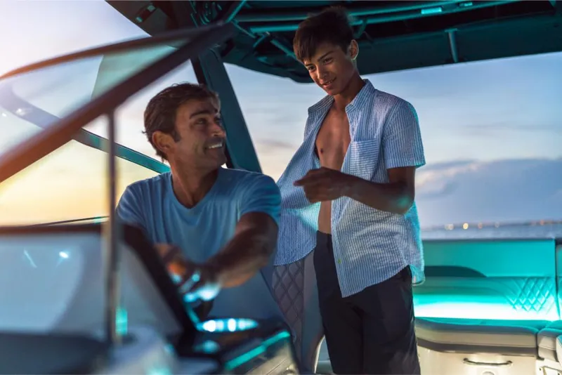 Slide: The Image of Father and son enjoying a sunset cruise on a 2023 Sea Ray SLX 260 boat. - 14