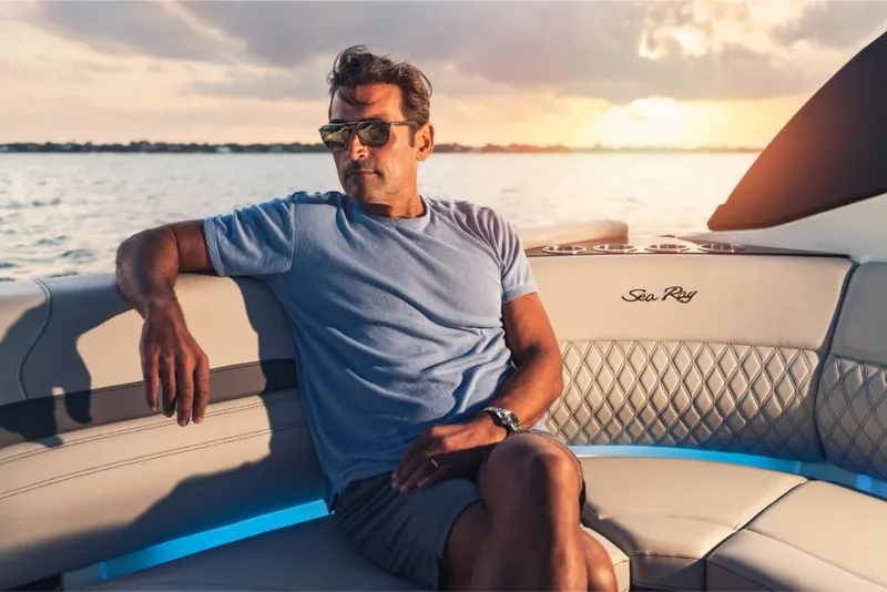 Slide: The Image of Man relaxing on a 2023 Sea Ray SLX 260 boat at sunset. - 15