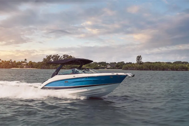 Slide: The Image of 2023 Sea Ray SLX 260 boat cruising on water at sunset. - 3